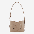 A tan leather handbag with a curved handle and a distinctive cutout in the front.