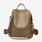 A tan leather backpack with multiple zippers and straps, designed for carrying various items.