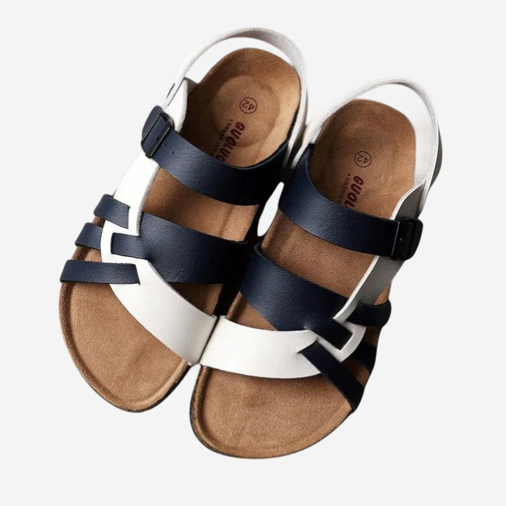 A pair of sandals with a combination of white and navy blue straps and soles.