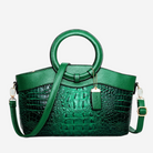 A green handbag with a crocodile skin texture and a round handle.