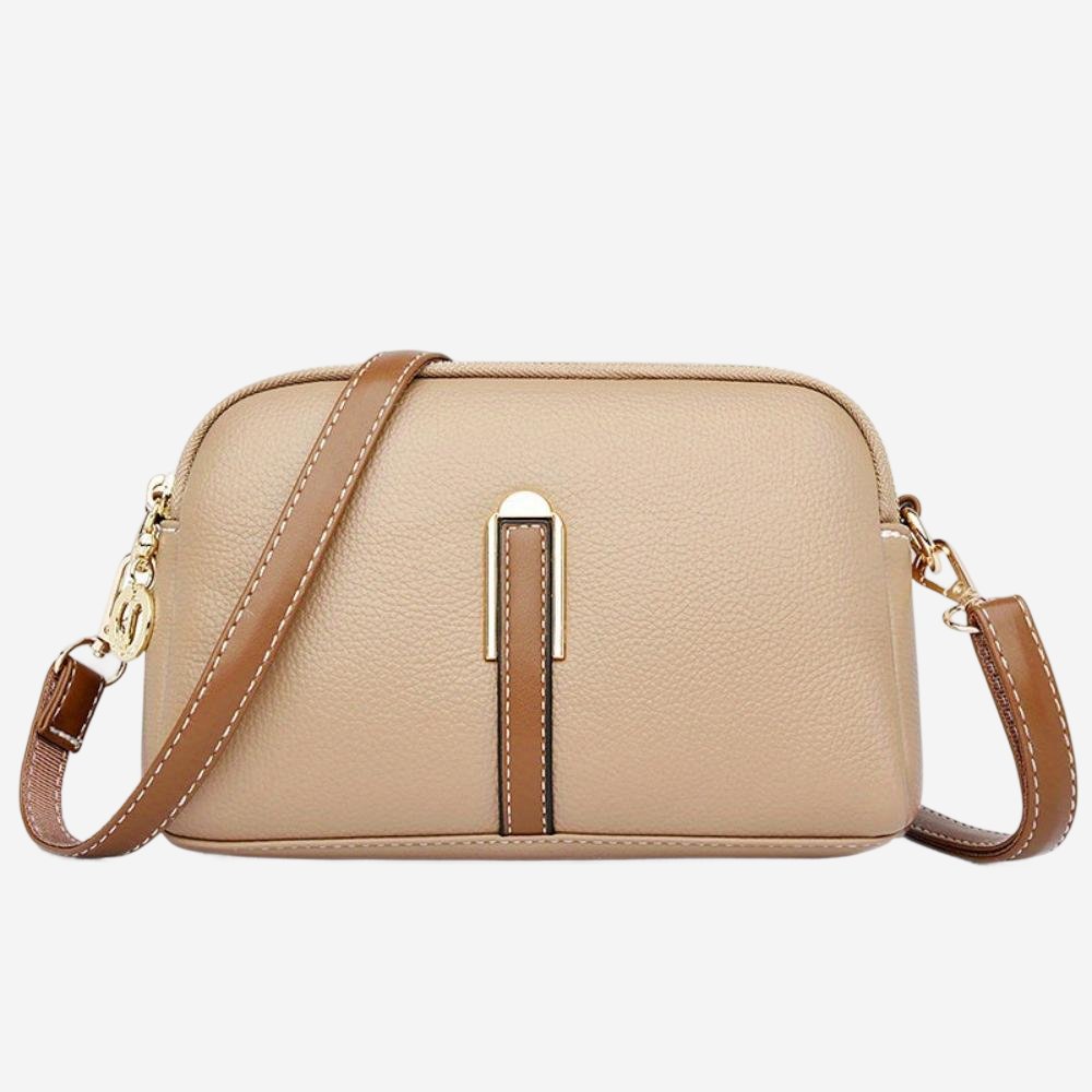 A tan leather crossbody bag with a gold-colored metal clasp and strap.