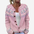 A woman wearing a pink knitted cardigan with a floral pattern.