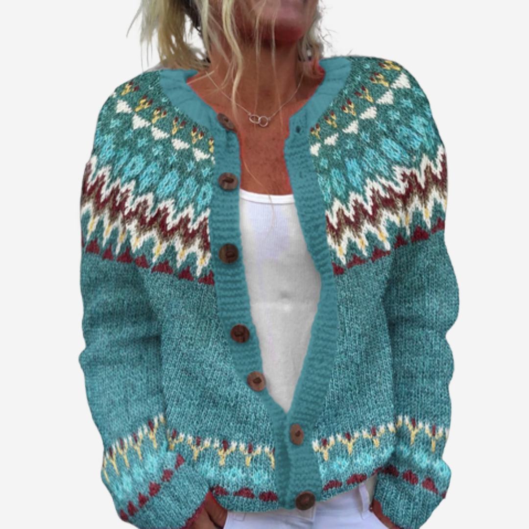 A woman wearing a teal-colored knitted cardigan with a patterned design.