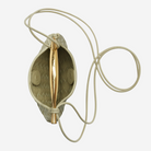 A small, beige-colored purse with a gold-colored handle and a gold-colored pen attached to it, hanging from a string.