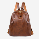 A brown leather backpack with a distinctive patchwork design.