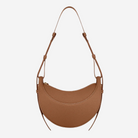 A brown leather handbag with a curved shape and a strap.