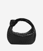 A black woven handbag with a distinctive knot detail on the front.