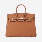 A brown leather handbag with a gold hardware and two straps.