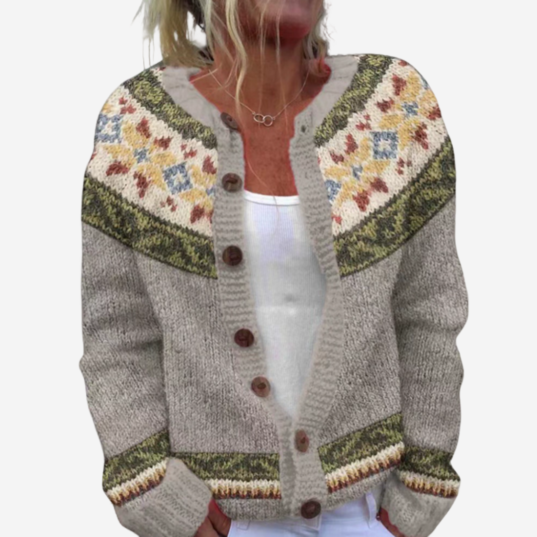 A woman wearing a gray cardigan with a colorful, patterned design on the front.