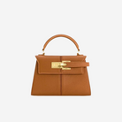 A small brown leather handbag with a gold-colored clasp and handle.