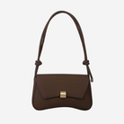 A brown leather handbag with a gold-colored clasp and a curved handle.